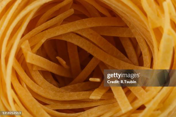 dried italian pasta, fettuccine nests, abstract food background, closeup shot - macro food stock pictures, royalty-free photos & images