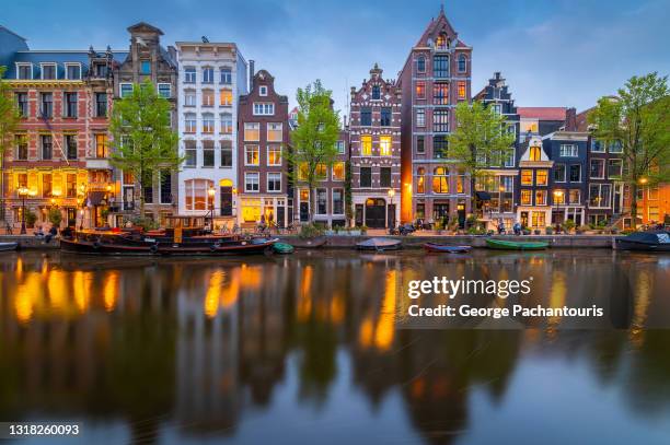 amsterdam city houses with lights on at dusk - amsterdam sunrise stockfoto's en -beelden