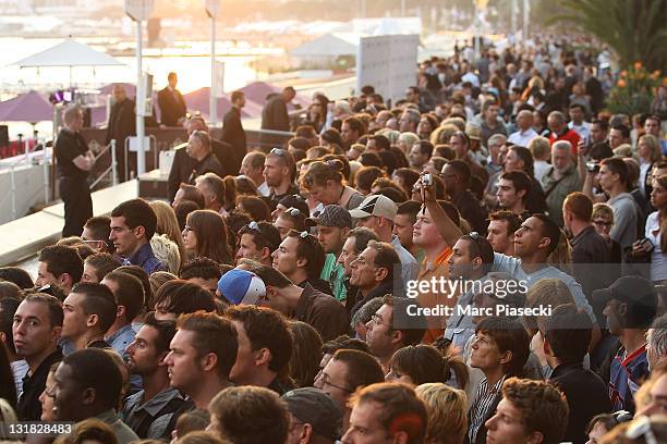 Crowd on 'La Croisette' attends the 'Le Grand Journal' TV show at Martinez Beach Pier on May 12, 2011 in Cannes, France.