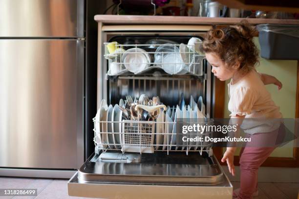 leuke kleine vaatwasser van het babymeisje, het concept van het belang van water - dishwasher stockfoto's en -beelden