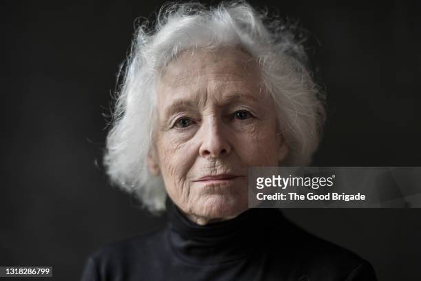 portrait of serious senior woman against black background - portrait fotografías e imágenes de stock