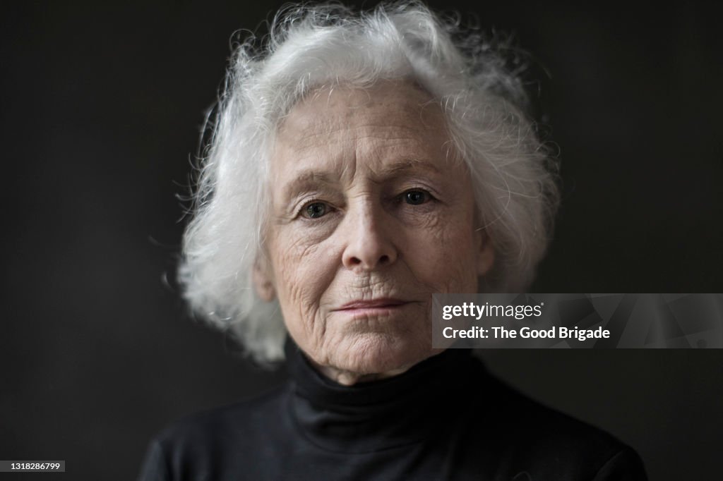 Portrait of serious senior woman against black background