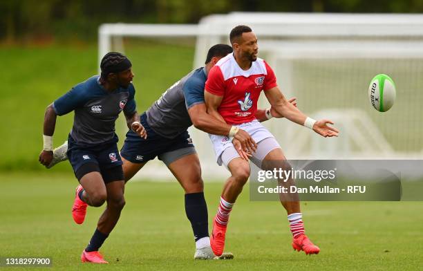 Dan Norton of Great Britain offloads under pressure from Martin Iosefo of the USA during the match between Great Britain and the USA on day two of...