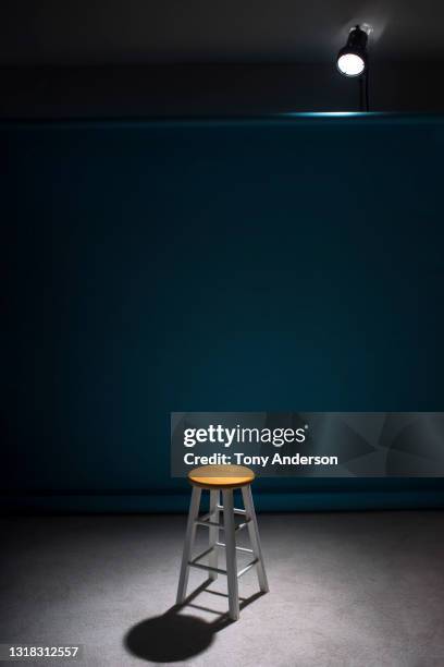 spotlight on empty stool on stage - sgabello foto e immagini stock