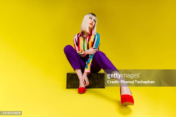 fashionable young woman in colorful outfit - mode stock-fotos und bilder