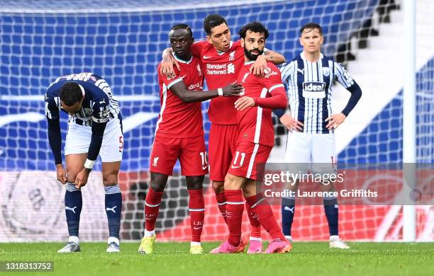 Mohamed Salah of Liverpool celebrates with Sadio Mane and Roberto Firmino after scoring their team's first goal as Kyle Bartley of West Bromwich...