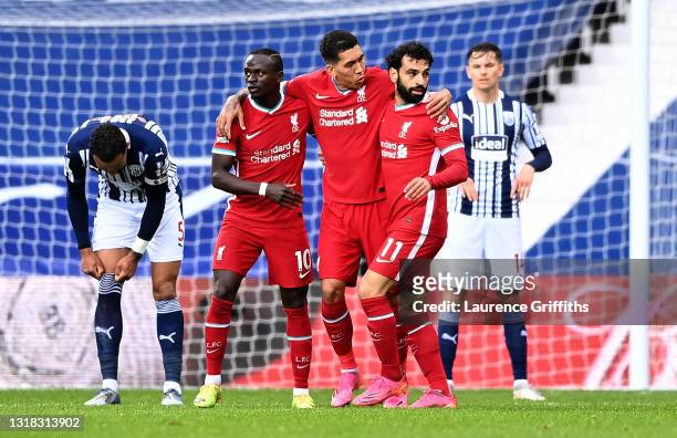 Mohamed Salah of Liverpool celebrates with Sadio Mane and Roberto Firmino after scoring their team's first goal as Kyle Bartley of West Bromwich...