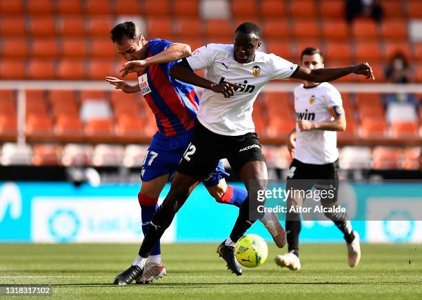 Kike of SD Eibar battles for possession with Mouctar Diakhaby of Valencia CF during the La Liga Santander match between Valencia CF and SD Eibar at...