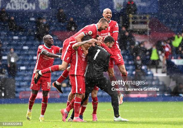 Alisson of Liverpool celebrates with team mates after scoring their side's second goal during the Premier League match between West Bromwich Albion...