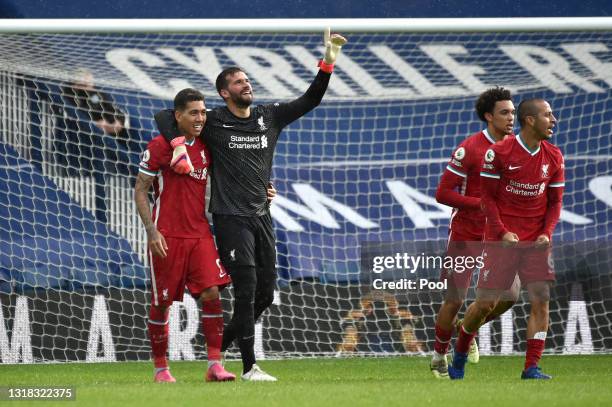 Alisson of Liverpool celebrates with team mate Roberto Firmino after scoring their side's second goal during the Premier League match between West...