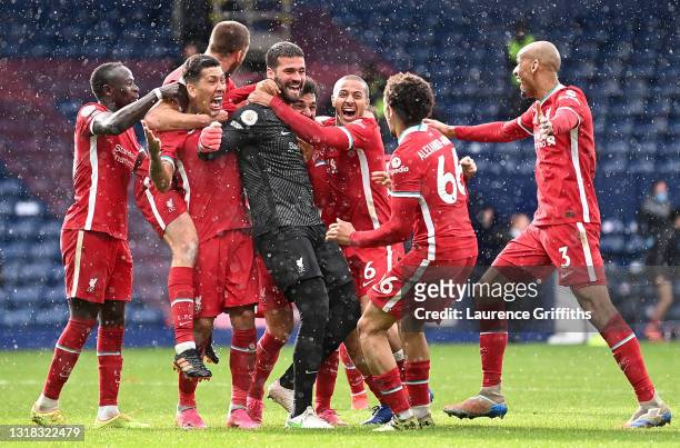 Alisson of Liverpool celebrates with Roberto Firmino, Thiago and team mates after scoring their side's second goal during the Premier League match...