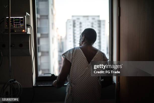 rear view of a patient at the hospital looking through window - patience stock pictures, royalty-free photos & images