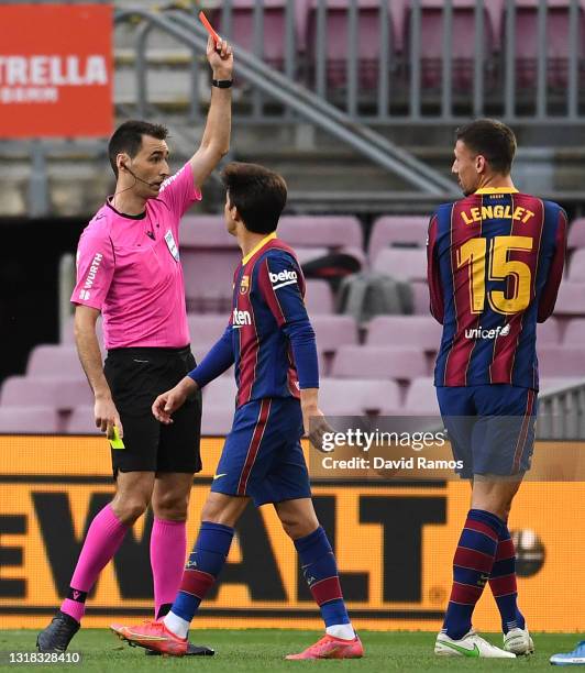 Clement Lenglet of FC Barcelona receives a red card from Ricardo De Burgos Bengoetxea, the match referee during the La Liga Santander match between...