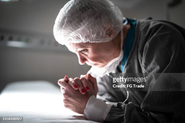 worried healthcare female nurse at operating room in hospital - nurse praying stock pictures, royalty-free photos & images