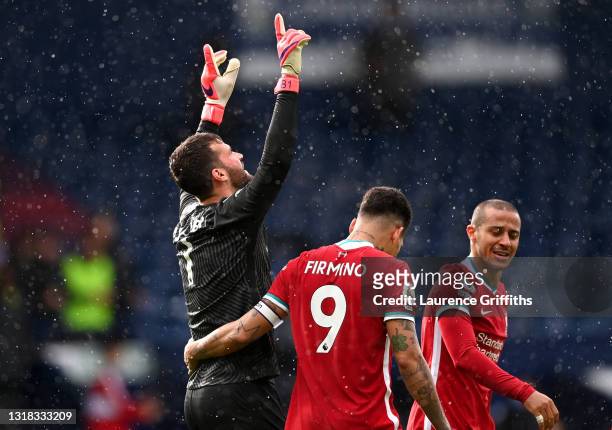 Alisson of Liverpool celebrates with team mate Roberto Firmino after scoring their side's second goal during the Premier League match between West...
