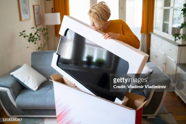 efter online shopping tar en kvinna leverans av sin nya tv - channel bildbanksfoton och bilder