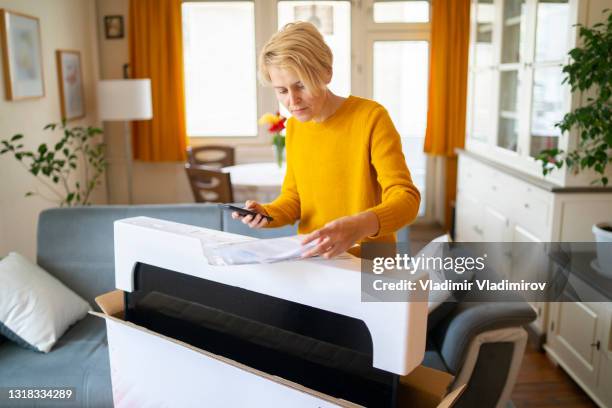 a woman checks her online purchase invoice and holding a mobile phone - electronic form stock pictures, royalty-free photos & images