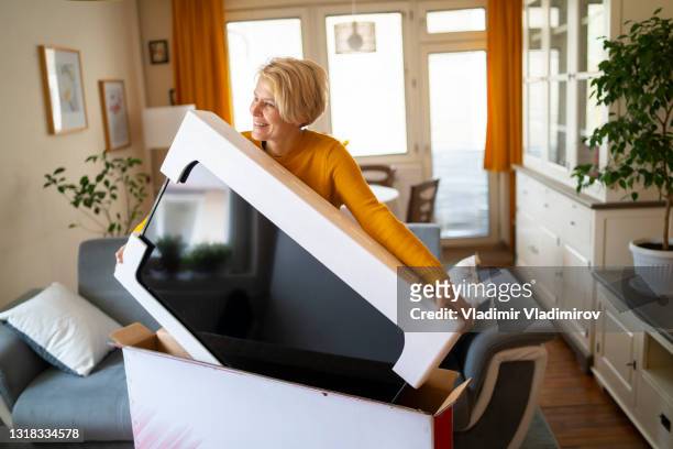 an online shopper lifts her new purchase from its box - new stock pictures, royalty-free photos & images