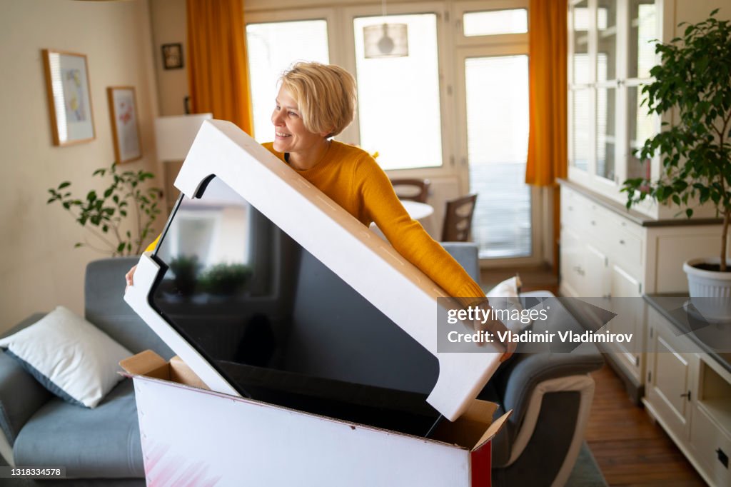 An online shopper lifts her new purchase from its box