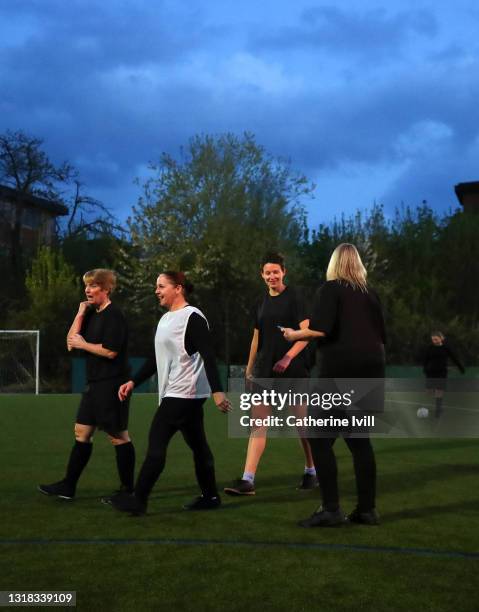 group of female soccer players leaving pitch after finishing a match at night - menopossibilities stock-fotos und bilder