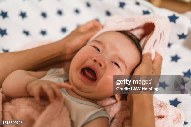 an adorable asian baby drying her hair on the bed - moms crying in bed stock pictures, royalty-free photos & images