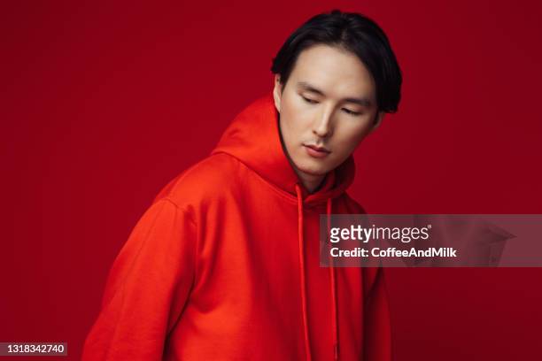 emotional asian man wearing hoodie - mens hair model stock pictures, royalty-free photos & images