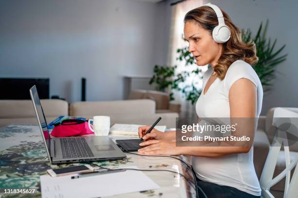 young pregnant woman tries to work remotely - parental leave stock pictures, royalty-free photos & images