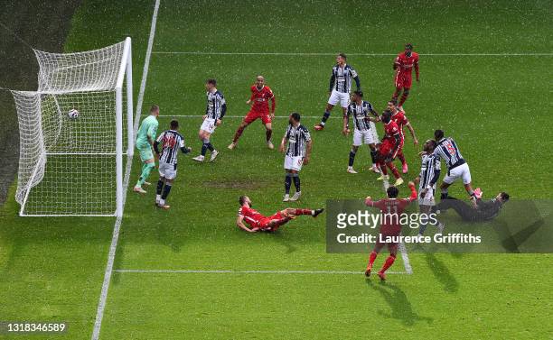 Alisson Becker of Liverpool scores the winning goal past Sam Johnstone of West Bromwich Albion during the Premier League match between West Bromwich...