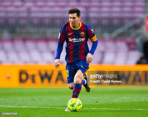 Lionel Messi of FC Barcelona runs with the ball during the La Liga Santander match between FC Barcelona and RC Celta at Camp Nou on May 16, 2021 in...