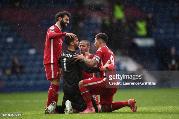 Alisson Becker of Liverpool is congratulated on scoring the winning goal by Mohamed Salah, Thiago Alcantara and Roberto Firmino during the Premier...