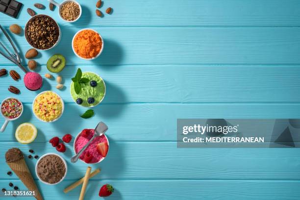 assorted ice cream cups and waffle cones colorful different flavor on blue wood - mint chocolate chip ice cream scoop stock pictures, royalty-free photos & images