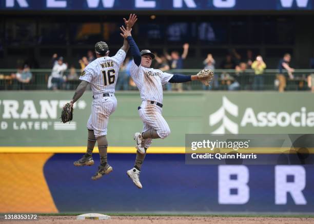 Luis Urias and Kolten Wong of the Milwaukee Brewers celebrate the team win against the Atlanta Braves at American Family Field on May 16, 2021 in...