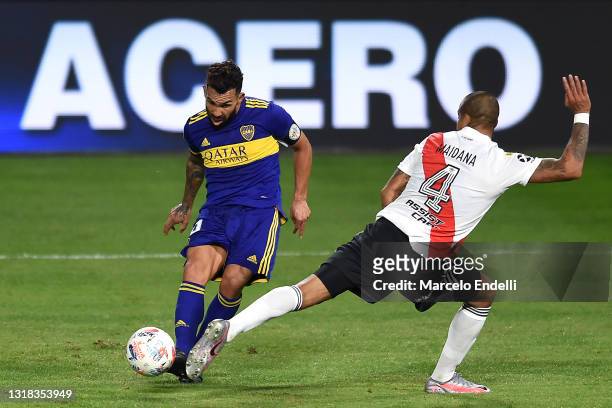 Carlos Tévez of Boca Juniors competes for the ball with Jonathan Maidana of River Plate during a quarter final match of Copa De La Liga Profesinal...
