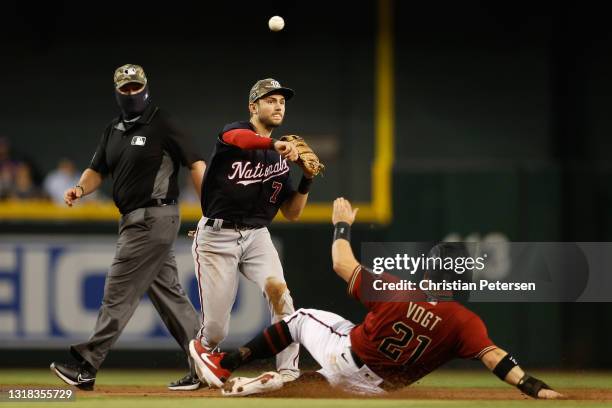 Infielder Trea Turner of the Washington Nationals throws over the sliding Stephen Vogt of the Arizona Diamondbacks to complete a double play during...