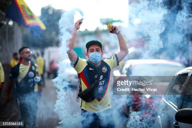 Fan of America uses smoke bombs to welcome his team to the Azteca Stadium before the quarterfinals second leg match between America and Pachuca as...