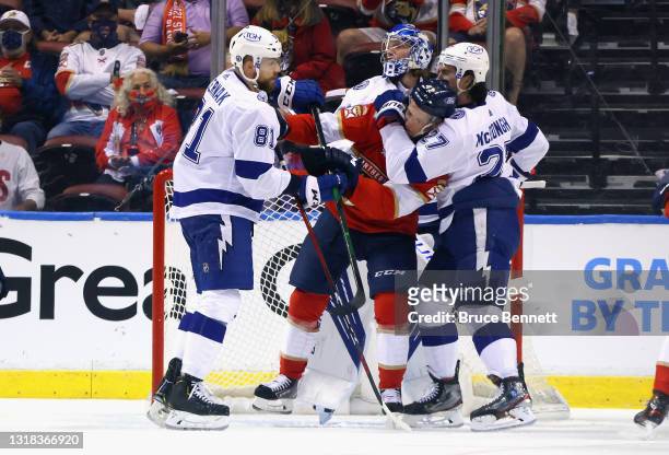 Erik Cernak and Ryan McDonagh of the Tampa Bay Lightning moves Gustav Forsling of the Florida Panthers from the crease during the first period in...