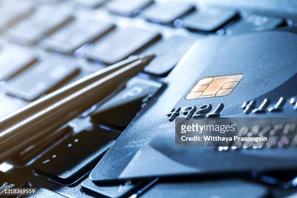credit card and ball pen on a laptop - credit card and stapel stockfoto's en -beelden