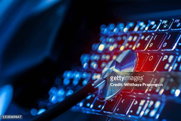 computer or data analysis - stethoscope over a laptop computer keyboard toned in blue - antivirus software bildbanksfoton och bilder