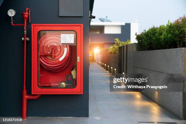 fire extinguisher and fire hose reel in hotel corridor - fire sprinkler stockfoto's en -beelden