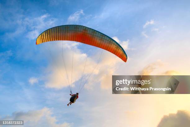 paraglider soaring in the blue sky - paragliding stock pictures, royalty-free photos & images