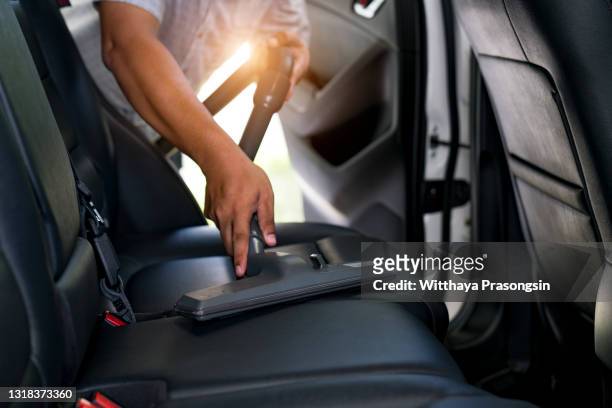 handyman vacuuming car back seat with vacuum cleaner - cleaning inside of car stock pictures, royalty-free photos & images