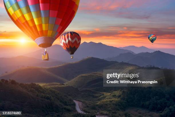 colorful hot-air balloons flying over the mountain - heißluftballon stock-fotos und bilder