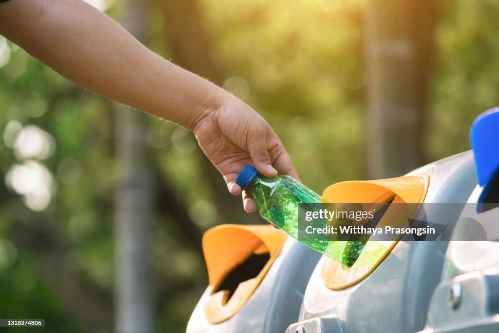 Close up hand throwing empty plastic bottle into the trash Recycling Concept