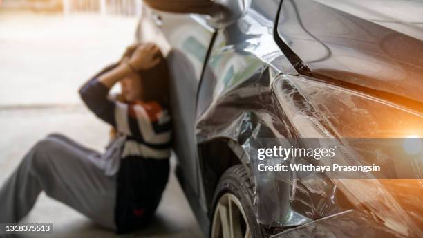 stressed driver sitting at roadside after traffic accident - car crash scene stock-fotos und bilder