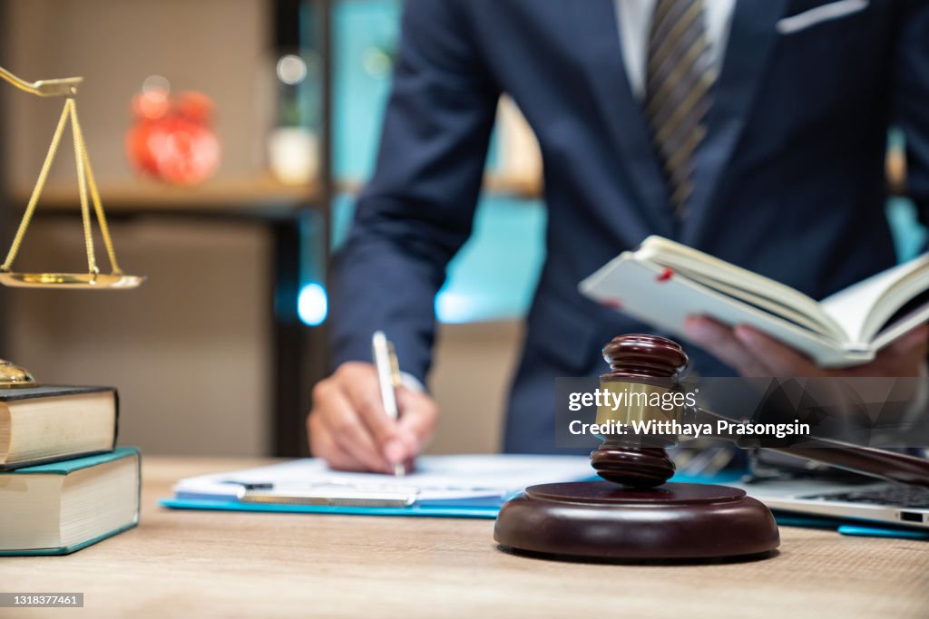 Close up lawyer businessman working or reading lawbook in office workplace for consultant lawyer concept