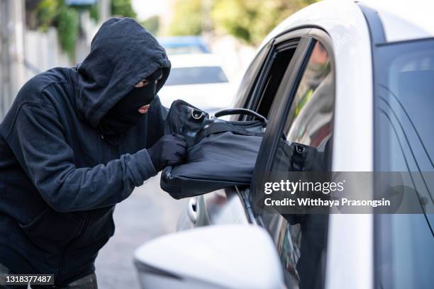burglar steal a shoulder bag through the window of car - entführung verbrechen stock-fotos und bilder