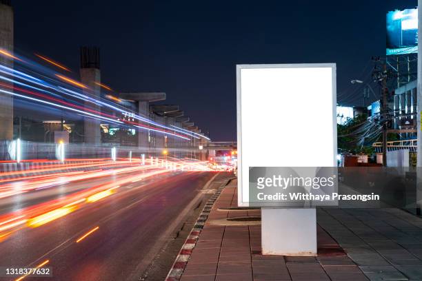 white blank billboard on light trails night street - blank advertising stock-fotos und bilder