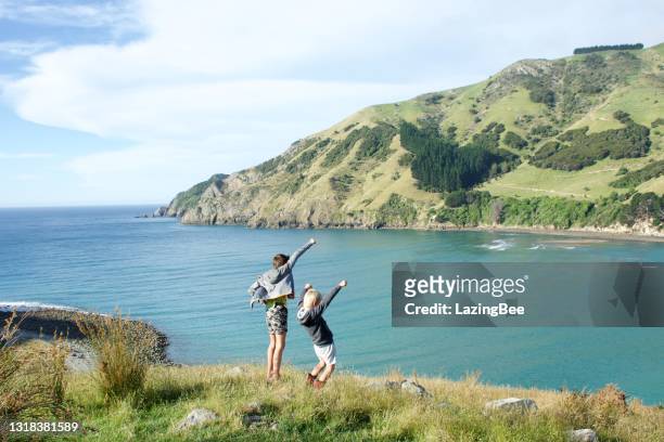 boys in rural coastal landscape with hands in the air - nelson stock pictures, royalty-free photos & images