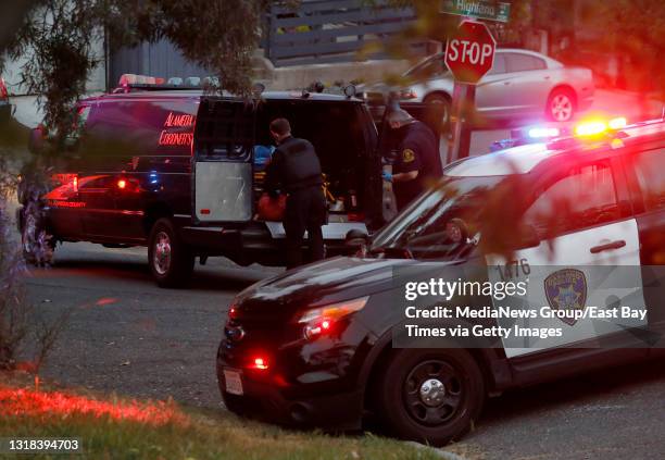 Alameda County Sheriff's Office Coroner's Bureau deputies prepares to transport one of the victims of a double homicide on East 26th Street near...