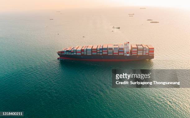aerial view container cargo ship going to terminal commercial port for load or unload at working crane bridge. business logistics, import export, shipping or freight transportation. - shipyard aerial stock pictures, royalty-free photos & images
